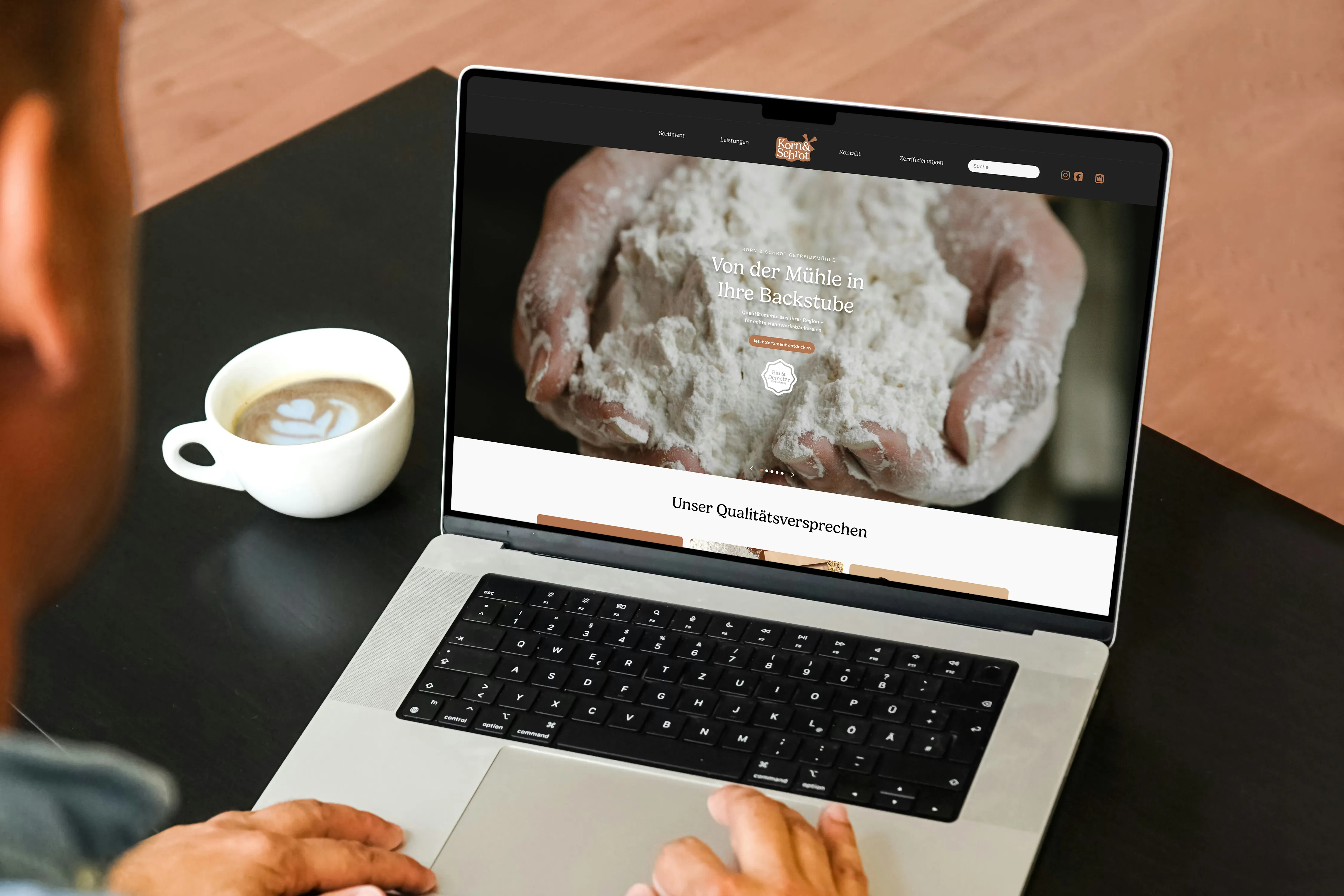 Mockup der Korn & Schrot Website auf einem MacBook in gemütlicher Café-Atmosphäre
